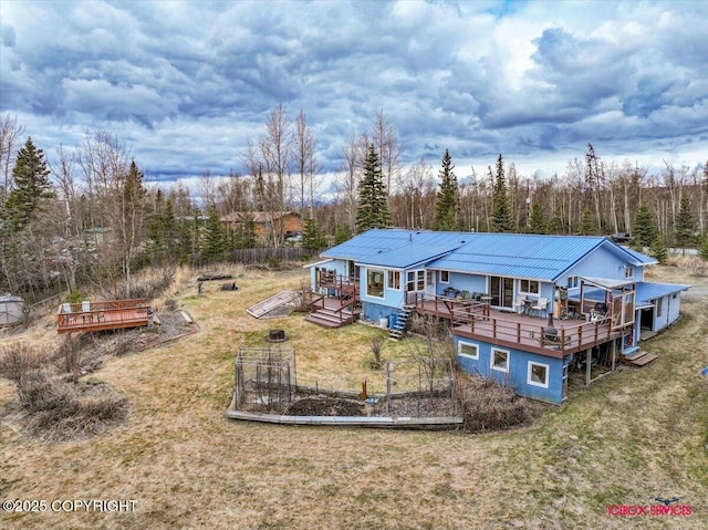 16500 E Smith Rd, Palmer, AK 99645 - back of house with metal roof, a yard, a garden, and a deck