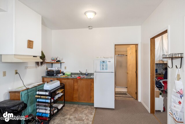 65265 Knob Hill Rd, Anchor Point, AK 99556 - kitchen with brown cabinetry, freestanding refrigerator, a sink, and dark countertops