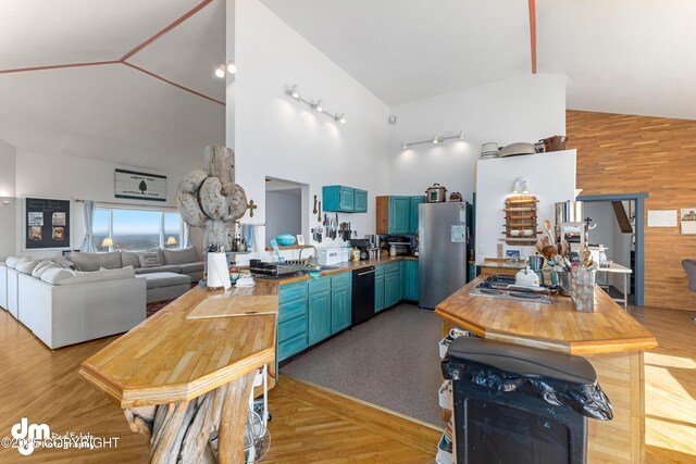 65265 Knob Hill Rd, Anchor Point, AK 99556 - kitchen with a sink, light wood-style flooring, freestanding refrigerator, high vaulted ceiling, and blue cabinets