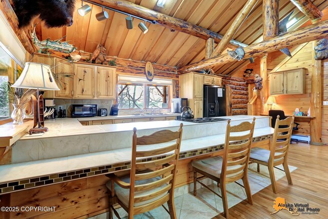 kitchen with black appliances, baseboard heating, wood ceiling, vaulted ceiling with beams, and light wood finished floors