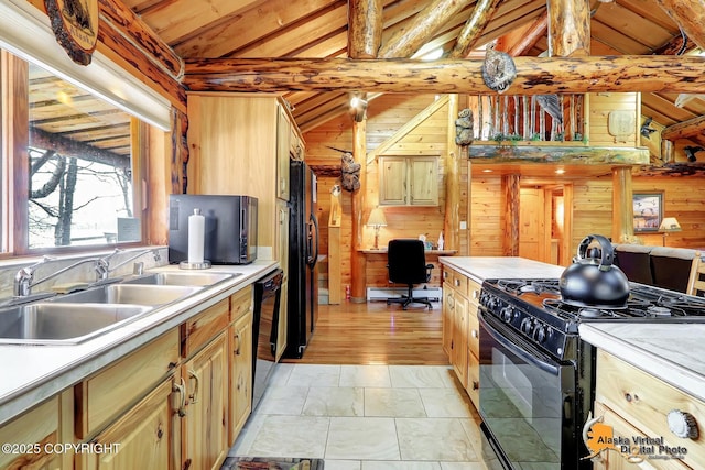 kitchen with lofted ceiling with beams, wooden walls, black appliances, a baseboard radiator, and a sink
