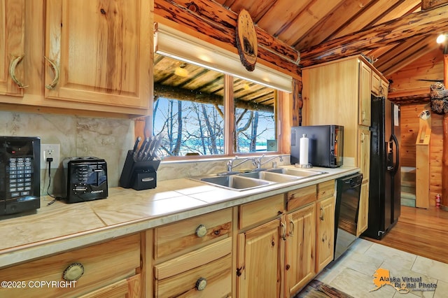 kitchen with a sink, wood ceiling, tile counters, black appliances, and vaulted ceiling