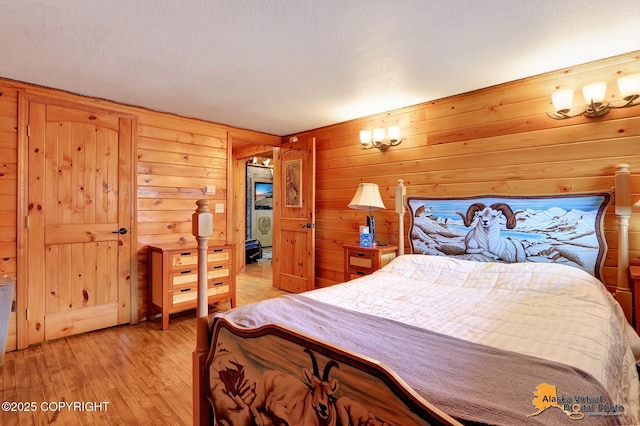 bedroom featuring light wood-type flooring and wood walls