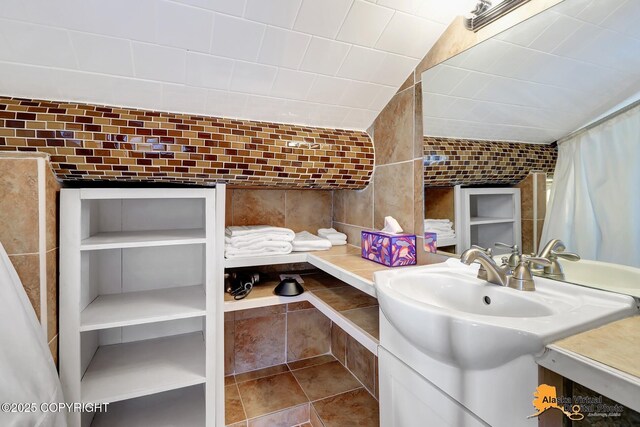 bathroom featuring vanity and tile walls