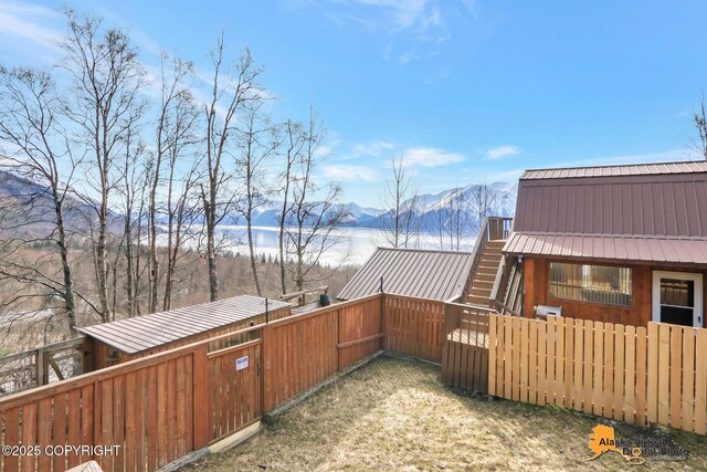 exterior space featuring stairs, a fenced backyard, and a mountain view