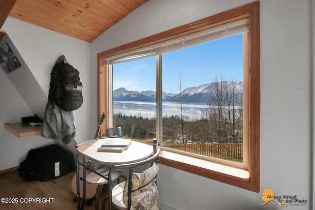 dining area with a water and mountain view, wooden ceiling, and vaulted ceiling