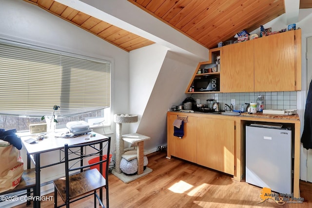 kitchen featuring light wood-style floors, tasteful backsplash, vaulted ceiling, wooden ceiling, and light countertops