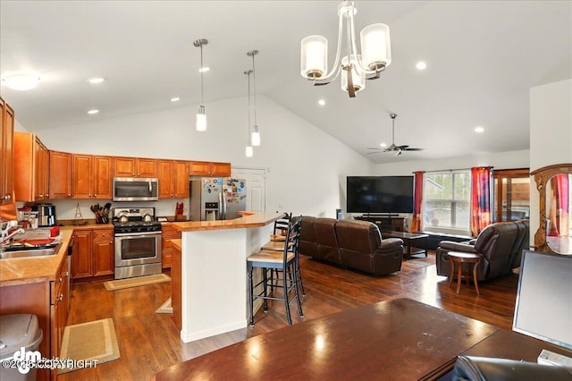 3762-3768 S Lansing Rd, Wasilla, AK 99654 - kitchen featuring stainless steel appliances, open floor plan, a sink, dark wood finished floors, and a breakfast bar area
