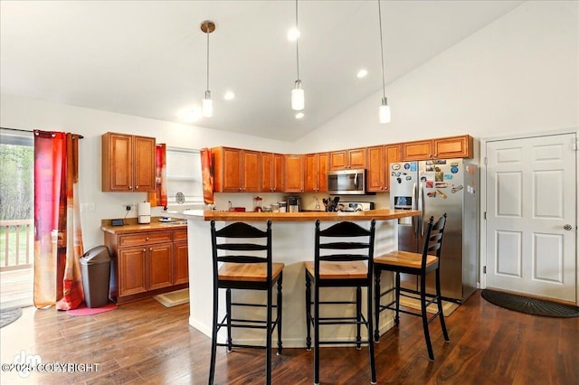 3762-3768 S Lansing Rd, Wasilla, AK 99654 - kitchen with stainless steel appliances, dark wood-style flooring, brown cabinets, a breakfast bar, and recessed lighting