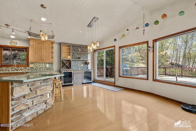 21440 Falling Water Cir, Eagle River, AK 99577 - kitchen with beverage cooler, decorative backsplash, open shelves, pendant lighting, and vaulted ceiling