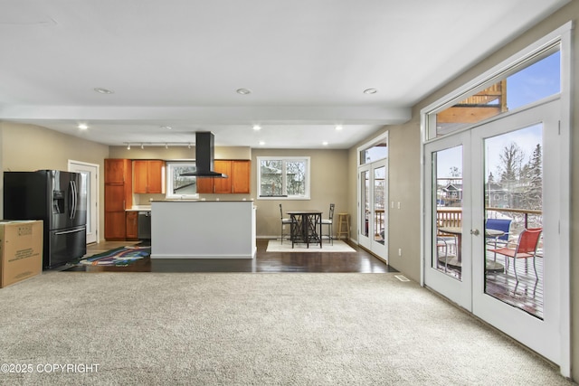 kitchen featuring stainless steel fridge with ice dispenser, carpet, recessed lighting, island range hood, and french doors