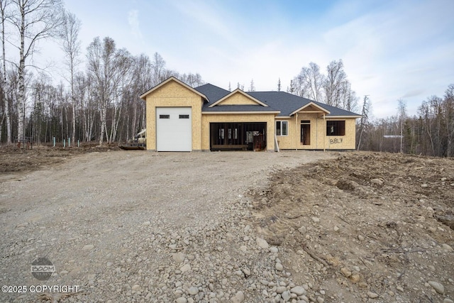 unfinished property featuring an attached garage and driveway