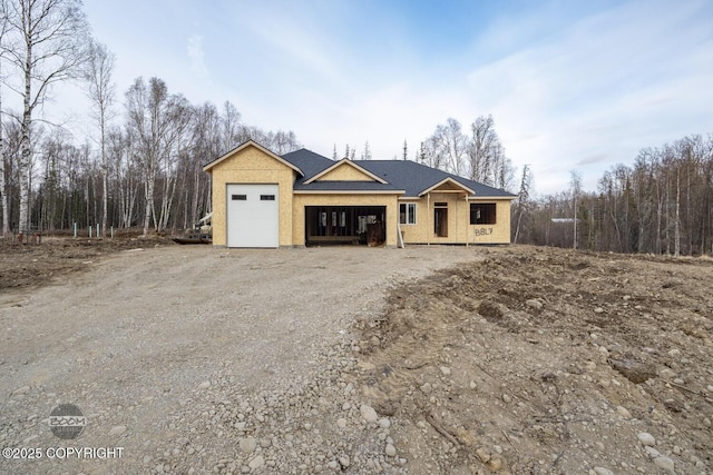 property in mid-construction featuring a garage and dirt driveway