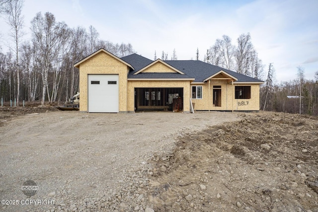 unfinished property with a garage and driveway