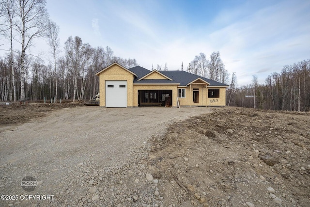 property under construction featuring dirt driveway and a garage