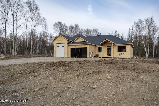 property in mid-construction with a garage and dirt driveway