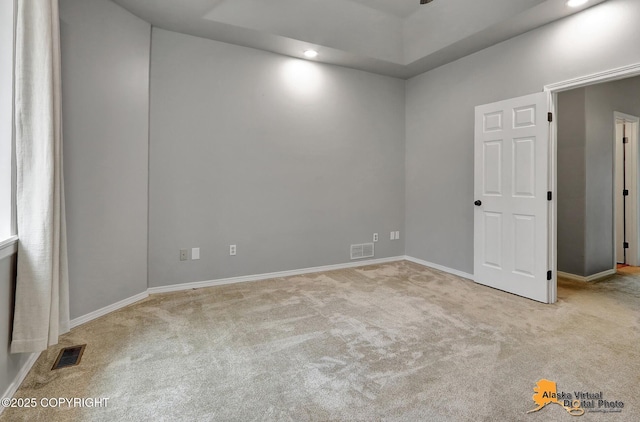 empty room featuring carpet, visible vents, baseboards, and ceiling fan
