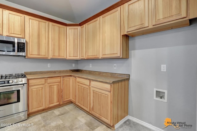 kitchen with light countertops, light brown cabinetry, and appliances with stainless steel finishes