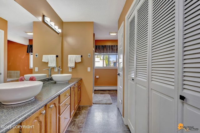 2500 Maylen Cir, Anchorage, AK 99516 - bathroom with a closet, double vanity, a baseboard heating unit, and baseboards