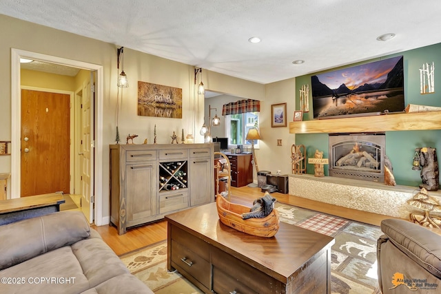 2500 Maylen Cir, Anchorage, AK 99516 - living area featuring light wood-style floors, a warm lit fireplace, and recessed lighting