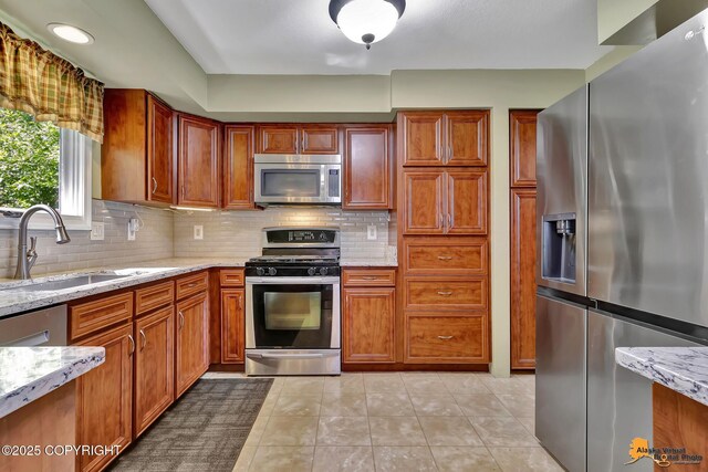 2500 Maylen Cir, Anchorage, AK 99516 - kitchen featuring appliances with stainless steel finishes, decorative backsplash, a sink, and light stone counters