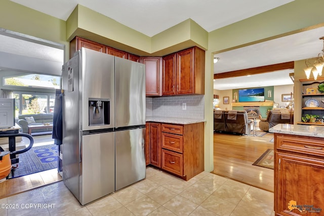 2500 Maylen Cir, Anchorage, AK 99516 - kitchen featuring stainless steel fridge, light stone counters, open floor plan, decorative backsplash, and beam ceiling