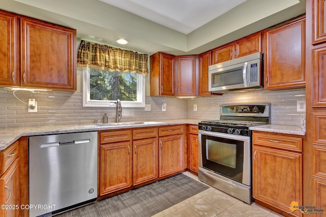 2500 Maylen Cir, Anchorage, AK 99516 - kitchen with appliances with stainless steel finishes, a sink, backsplash, light tile patterned floors, and light stone countertops