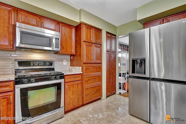 2500 Maylen Cir, Anchorage, AK 99516 - kitchen featuring appliances with stainless steel finishes, decorative backsplash, light tile patterned floors, brown cabinetry, and light stone counters