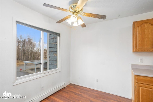 315 Krane Dr # 19, Anchorage, AK 99504 - unfurnished dining area with a baseboard heating unit, ceiling fan, baseboards, and wood finished floors