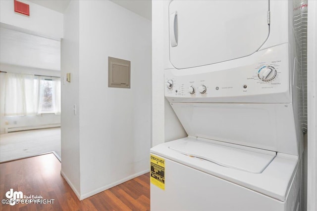 315 Krane Dr # 19, Anchorage, AK 99504 - laundry area featuring stacked washer and clothes dryer, laundry area, wood finished floors, baseboards, and a baseboard radiator