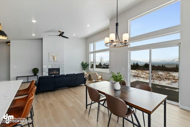 1029 Shelley Ave, Homer, AK 99603 - dining room featuring a premium fireplace, a chandelier, recessed lighting, light wood-type flooring, and ceiling fan