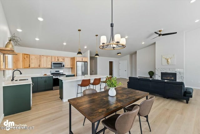1029 Shelley Ave, Homer, AK 99603 - dining room with vaulted ceiling, light wood-type flooring, a chandelier, a premium fireplace, and recessed lighting