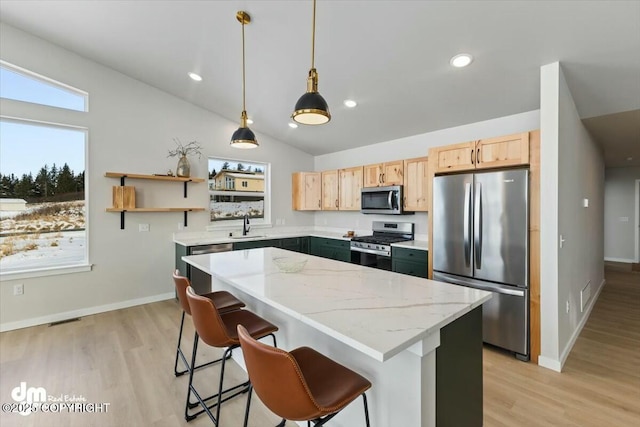 1029 Shelley Ave, Homer, AK 99603 - kitchen with appliances with stainless steel finishes, light brown cabinetry, light wood-style flooring, a center island, and hanging light fixtures