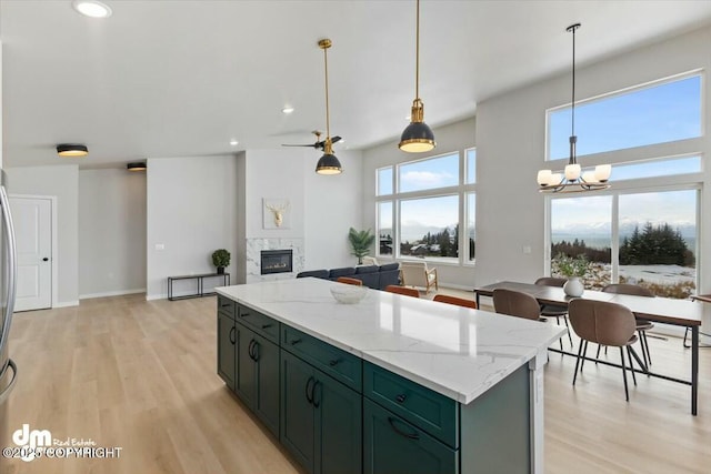 1029 Shelley Ave, Homer, AK 99603 - kitchen with light wood-style flooring, a fireplace, a chandelier, pendant lighting, and recessed lighting