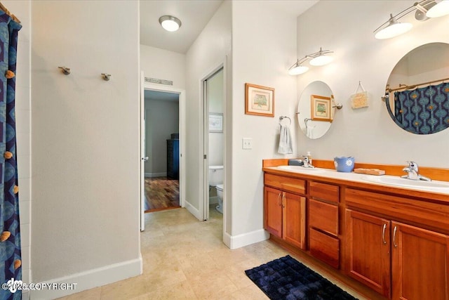 3361 N Inspiration Loop, Wasilla, AK 99654 - bathroom featuring toilet, double vanity, tile patterned floors, and baseboards