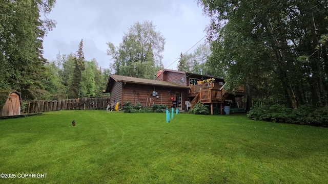 view of yard featuring a wooden deck, fence, and stairway