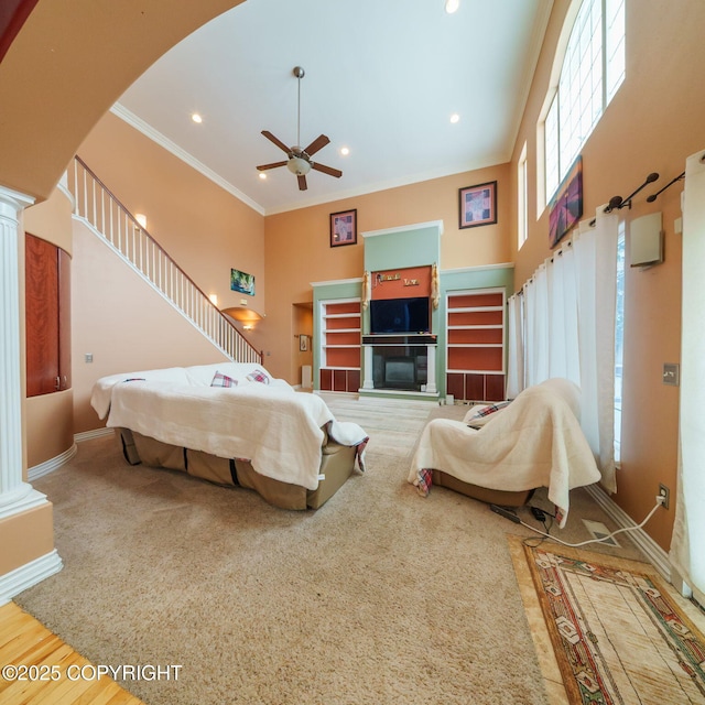 bedroom with crown molding, ornate columns, arched walkways, and a high ceiling