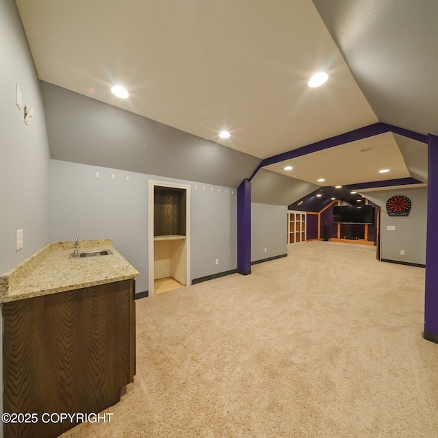 bonus room featuring carpet flooring, indoor wet bar, vaulted ceiling, and a sink