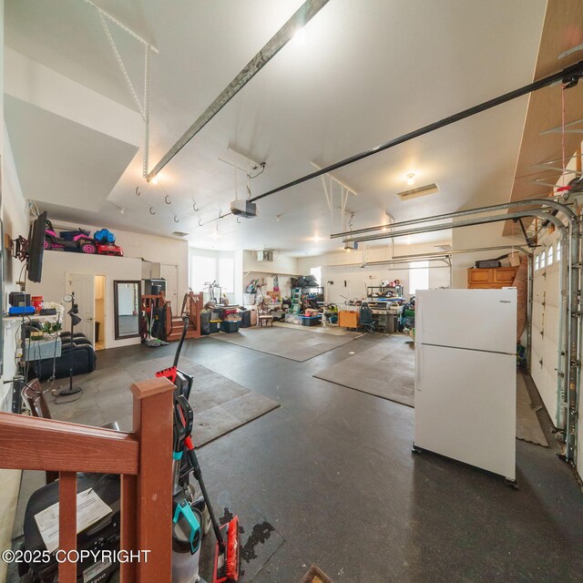 garage featuring a garage door opener and freestanding refrigerator