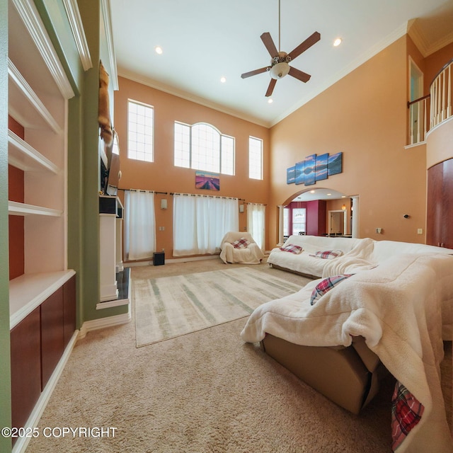 carpeted bedroom featuring a high ceiling, multiple windows, and crown molding