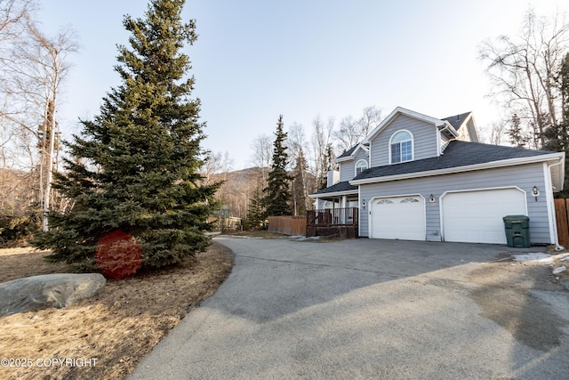 10127 Crest View Ln, Eagle River, AK 99577 - view of property exterior featuring aphalt driveway, fence, and a shingled roof