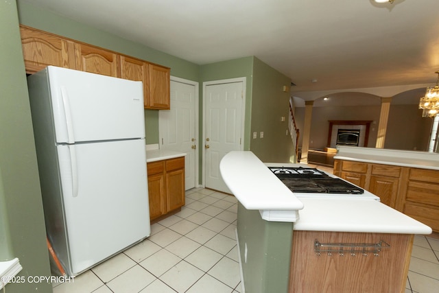 10127 Crest View Ln, Eagle River, AK 99577 - kitchen featuring freestanding refrigerator, light countertops, a glass covered fireplace, and light tile patterned floors