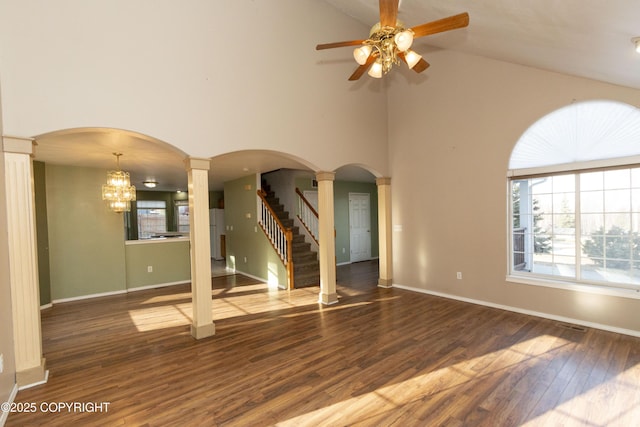 10127 Crest View Ln, Eagle River, AK 99577 - unfurnished living room with ornate columns, wood finished floors, ceiling fan with notable chandelier, and arched walkways