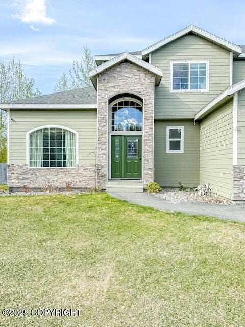 2731 E Tamarak Ave, Wasilla, AK 99654 - view of front facade featuring stone siding and a front lawn