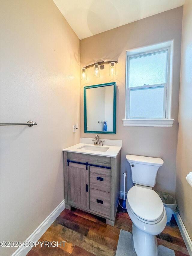 2731 E Tamarak Ave, Wasilla, AK 99654 - half bathroom with vanity, toilet, wood finished floors, and baseboards