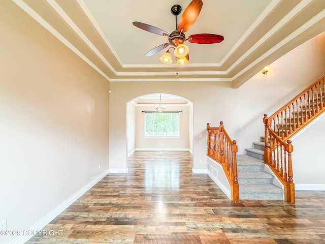 2731 E Tamarak Ave, Wasilla, AK 99654 - stairway with arched walkways, wood finished floors, a ceiling fan, a tray ceiling, and ornamental molding