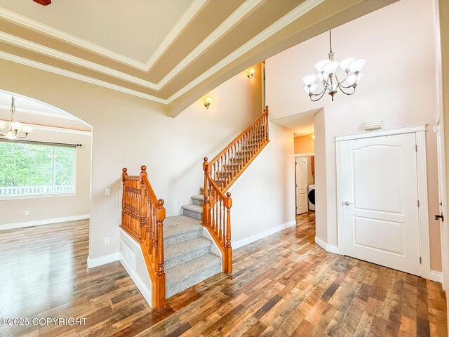 2731 E Tamarak Ave, Wasilla, AK 99654 - staircase with a chandelier, wood finished floors, ornamental molding, arched walkways, and washer / clothes dryer