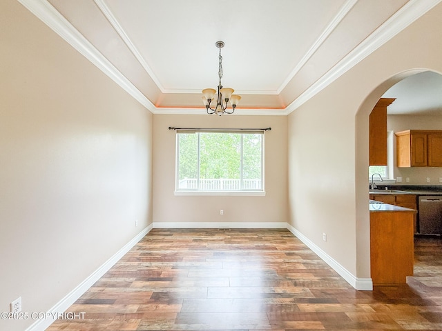 2731 E Tamarak Ave, Wasilla, AK 99654 - unfurnished dining area featuring wood finished floors, arched walkways, a chandelier, a tray ceiling, and baseboards