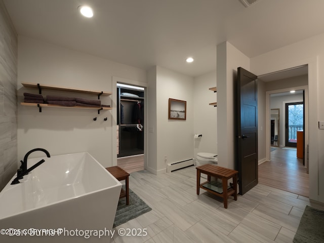 11730 Broadwater Dr, Eagle River, AK 99577 - full bath featuring baseboard heating, a freestanding tub, a sink, toilet, and recessed lighting