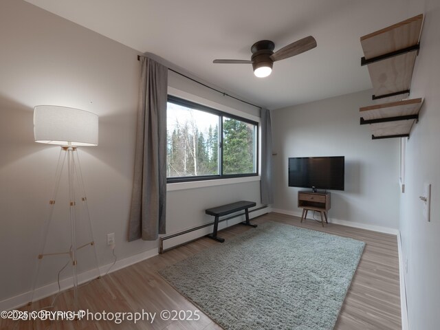 11730 Broadwater Dr, Eagle River, AK 99577 - living area with a baseboard heating unit, wood finished floors, a ceiling fan, and baseboards